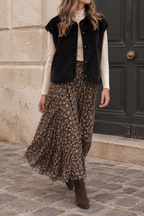 Veste fausse fourrure noire Season portée ouverte en mode automnal avec jupe longue fleurie | Coka Collection