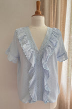 Blouse Enola brodée bleu ciel – vue de face, décolleté en V et volants brodés | Coka Collection