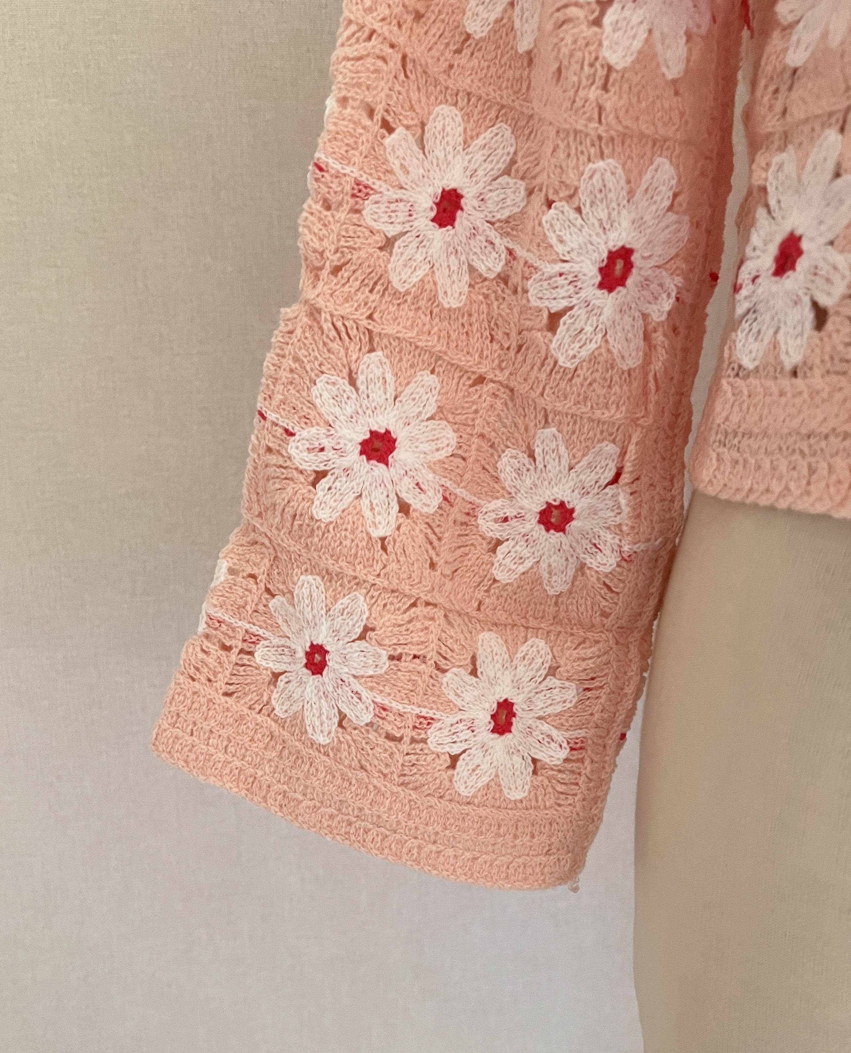 Pull crochet Aubin fleuri rose poudré Coka Collection – détail manche évasée | Coka Collection