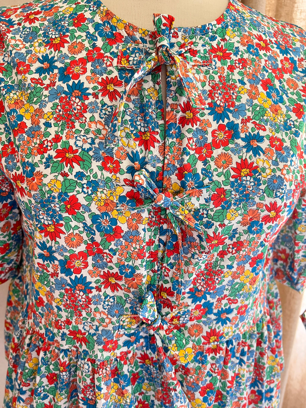 Blouse Carla fleurie à nœuds Lili & Lala – détail nœuds et encolure ronde | Coka Collection