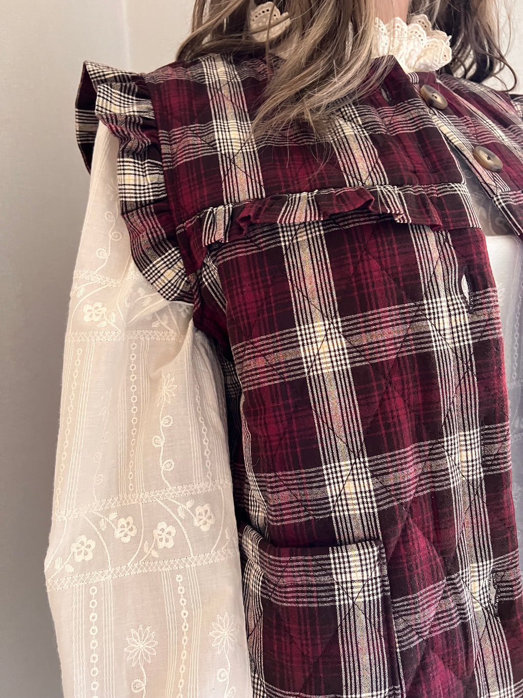 Gilet Victor, détail des volants à l’épaule et sur le devant, porté sur une blouse écrue | Coka Collection